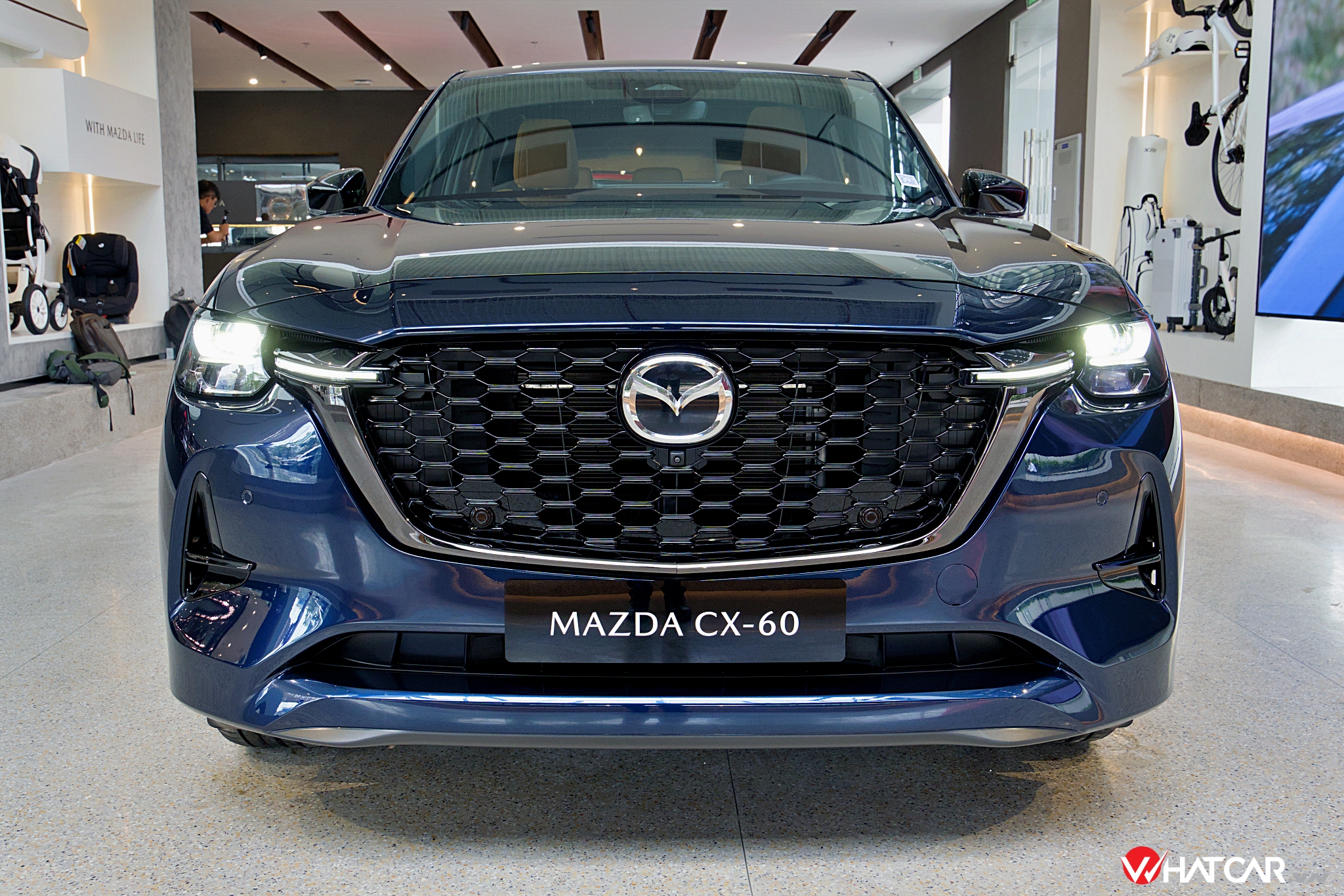 Hãng cũng vẽ lại cụm đèn pha LED thích ứng tự động trên Mazda CX-60, trông to bản hơn thường lệ với các bóng đèn và dải đèn định vị hình chữ "L" xếp chồng lên nhau. Góc cản trước được khoét sâu thành khe hút gió, nâng cao tính khí động học và tôn thêm vẻ khỏe khoắn cho chiếc SUV 5 chỗ (Ảnh: Trung Nghĩa).