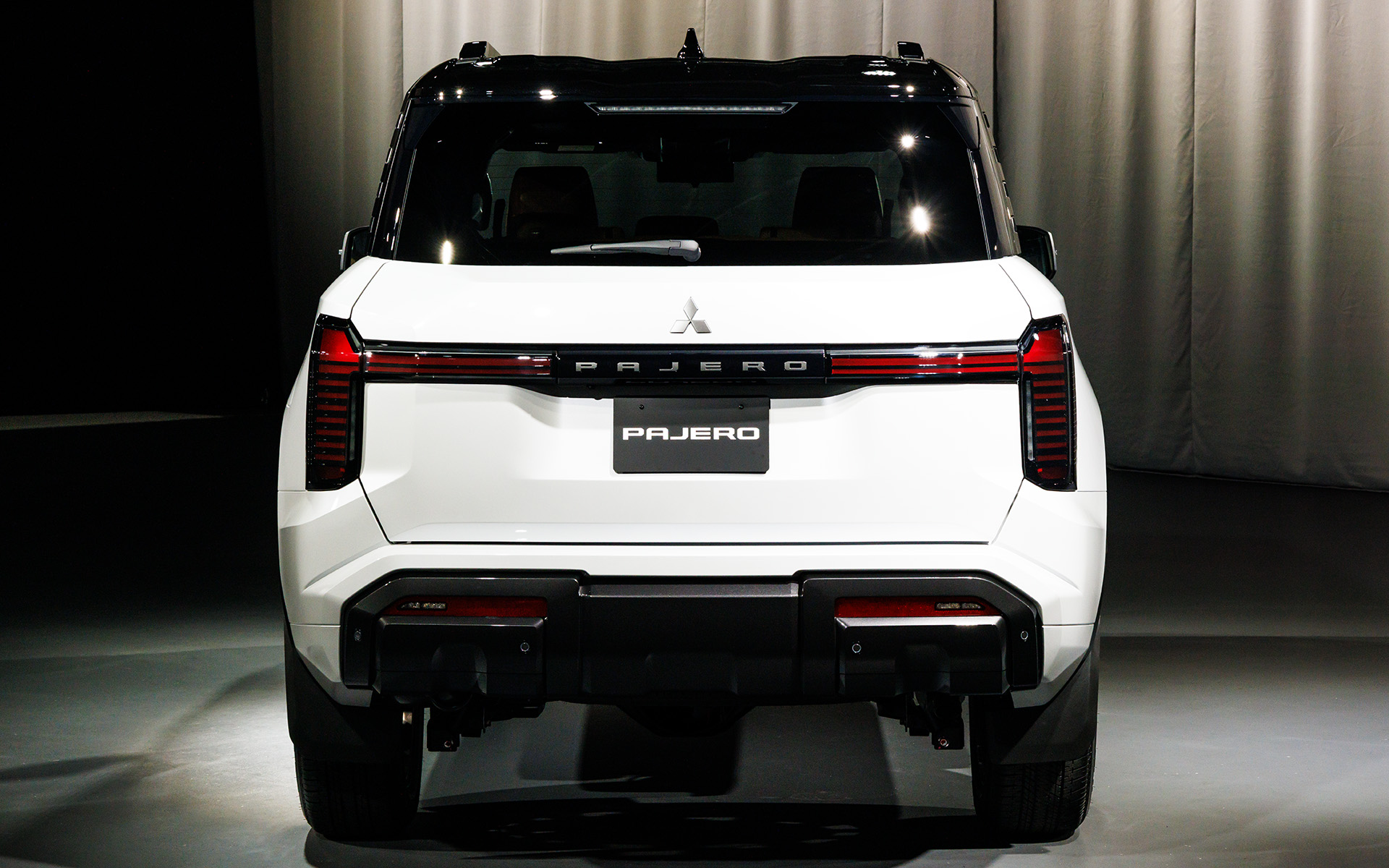 Phía sau, cụm đèn hình chữ "T" nối liền dòng chữ "Pajero". Cửa hậu được lấy cảm hứng từ tấm ốp lốp dự phòng hình lục giác trên Pajero đời thứ 4, song sự biến mất của chi tiết thuần việt dã này vẫn khiến nhiều người tiếc nuối. Kính cách âm hai lớp áp dụng ở phía trước và bên sườn, đi kèm loạt giải pháp cách ly và triệt tiêu tiếng ồn, hứa hẹn trải nghiệm thoải mái hơn cho người dùng.